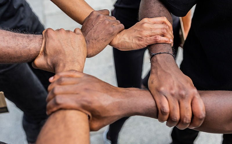 faceless black friends joining hands on urban pave 2023 11 27 05 28 17 utc